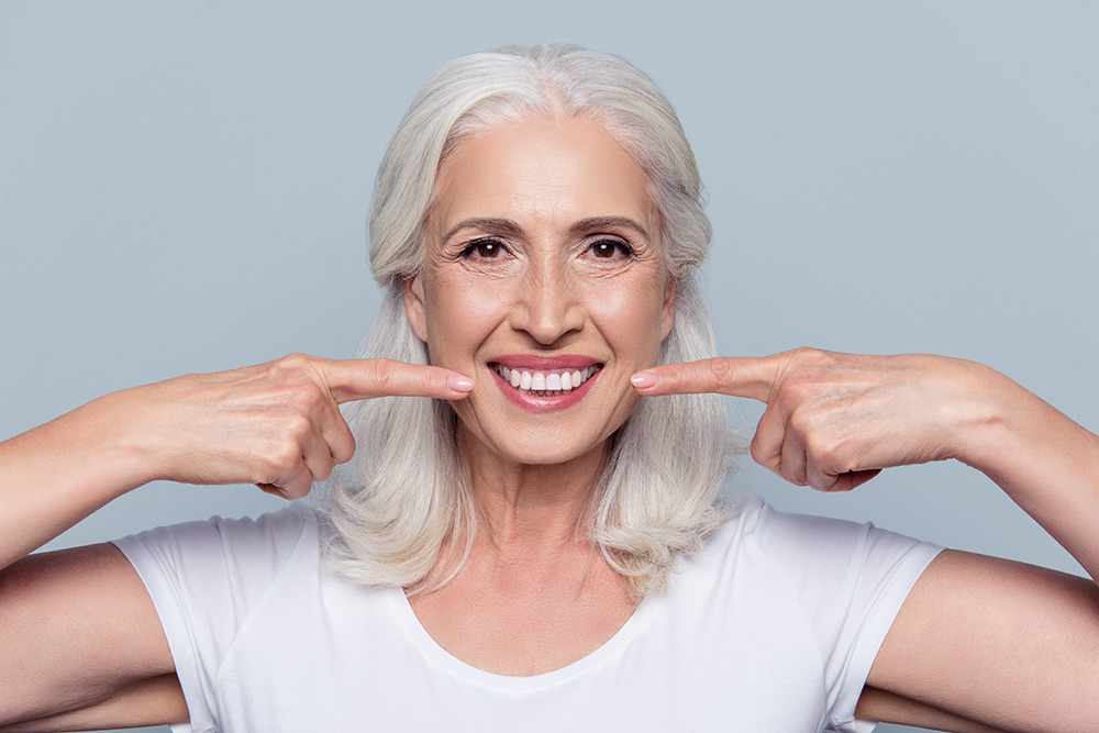 old lady pointing her newly whitened teeth with zoom teeth whitening